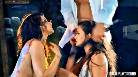 Two topless long-haired brunettes kneel eagerly before muscular shirtless stud in outdoor threesome tease