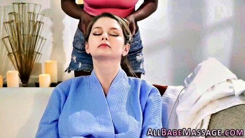 Black masseuse sensually massaging white babe's shoulders in erotic robe session