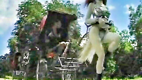 Ponygirl in white harness costume pulled by cart in outdoor BDSM fetish scene