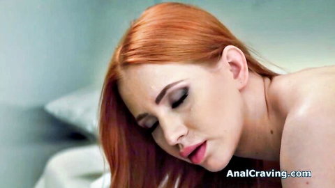 Busty redhead nude on bed, looking back seductively in anal scene