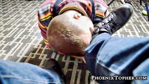 Man in striped sweater adores dominant boots on face in foot fetish scene