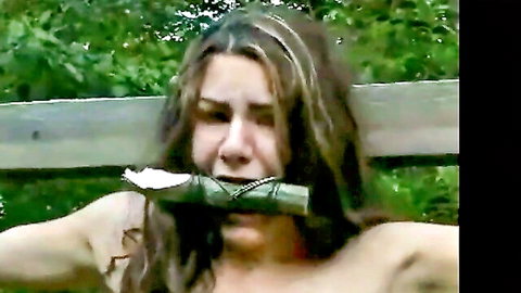 Brunette woman gagged and struggling topless outdoors, bondage fetish scene