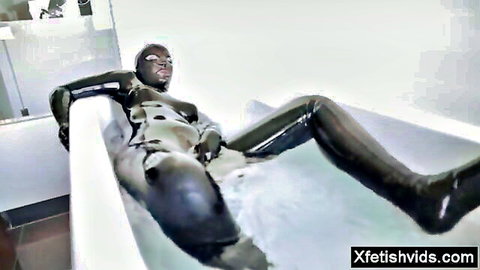 Hot pornstar in black latex catsuit lounging in bubble bath with cumshot