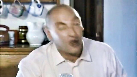 Bald mature man in pink shirt reacting in kitchen, Penelope 1996 maid scene