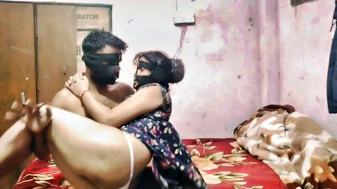 Passionate Indian desi bhabhi in floral dress embracing lover on bed