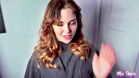Ellie Skyes smiling seductively in gray cape, teasing forbidden connection