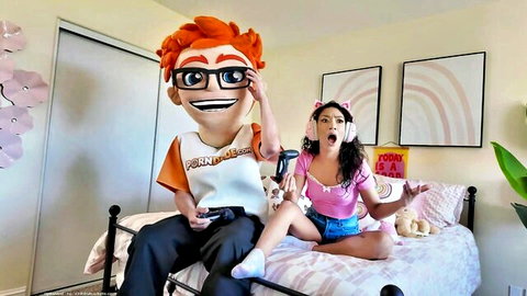 Sarah Lace in pink crop top and shorts with mascot, playful bedroom tease