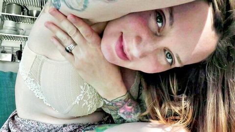 Tattooed curvy MILF smiles seductively in lace bra teasing big tits cleavage POV selfie