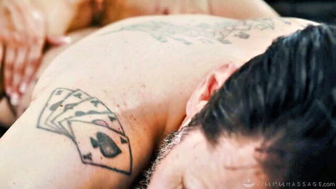 Masseuse hands rubbing tattooed man's neck and shoulder in erotic massage