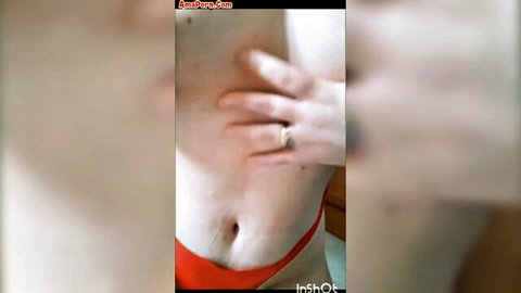 Close-up of slim woman in red thong touching her belly
