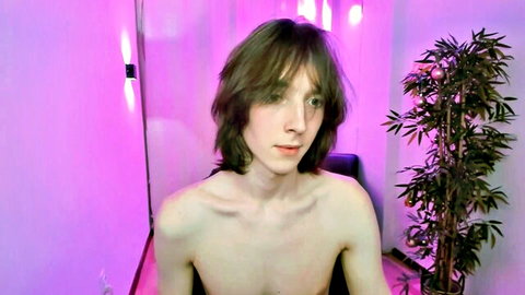 Shirtless white twink with shaggy brown hair in gay camshow