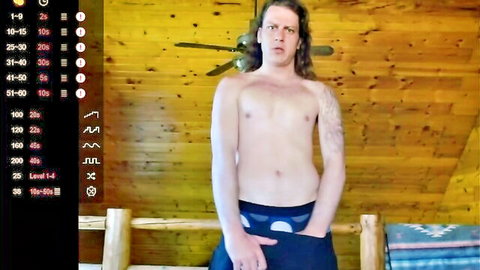 Shirtless long-haired muscular man in underwear posing in rustic setting