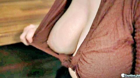 Busty woman flashing large pale breasts in open brown cardigan