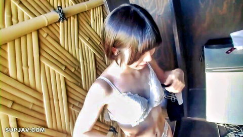 Asian babe in white lace bra and thong bending over in bamboo-walled bathroom