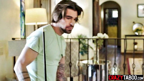 Tattooed handsome stepbrother in green tee, holding cue in doctor roleplay scene