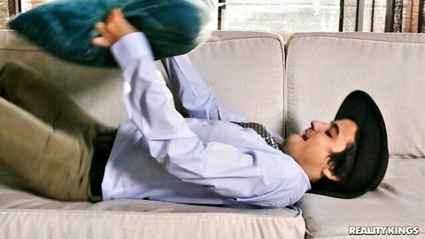 Ricky Spanish playfully holding pillow in intense fetish scene