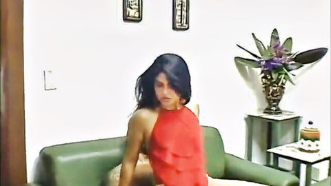 Sassy brunette in red halter top, seductive pose on couch craving deep dicking