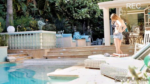 Blonde Kristen Scott in tiny denim shorts bends over by pool in voyeur backyard tease