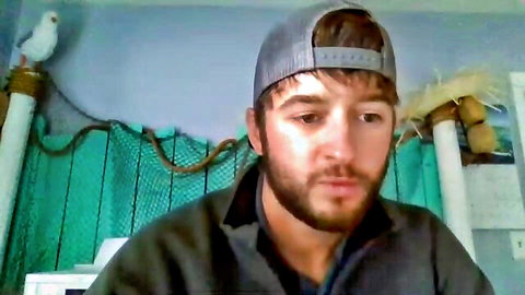 Handsome bearded Asian man in cap, smiling for gay video