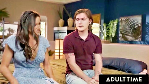 Penny Barber in blue dress coaches young stepson on bed