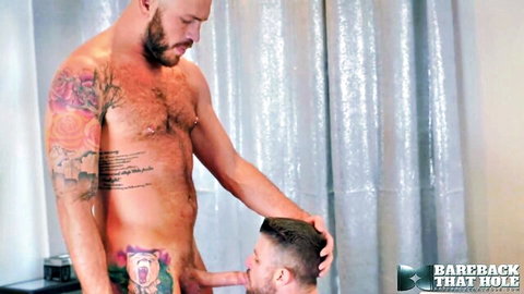 Muscular tattooed bearded bear getting oral from kneeling guy in bareback scene