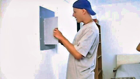 Young Asian guy in cap reaching through wall glory hole for housewife