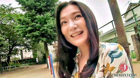 Smiling Japanese woman in floral blouse outdoors, pleased by intimate washing