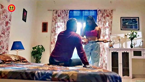 Desi woman in blue crop top and jeans teases sitting man in bedroom