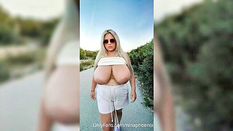 Blonde Nina Phoenix walks outdoors in tight white tube top and shorts, huge tits bulging