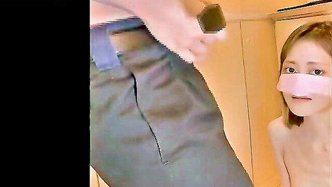Blindfolded nude Japanese girl peeks out surprised by clothed man holding phone to her bare small tits