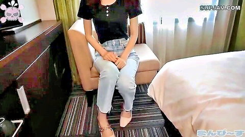 Asian woman in jeans sitting seductively with legs apart