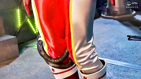 Asian woman in red wrestling shorts teases with black dildo