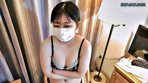 Young Asian woman in black lace lingerie and face mask, teasing with crossed arms
