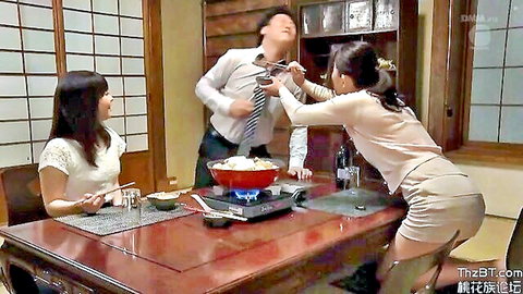 Asian women seducing suited man with hot pot at dinner