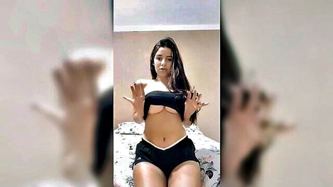 Sexy Brazilian girl Andy posing in black bandeau top and shorts on bed