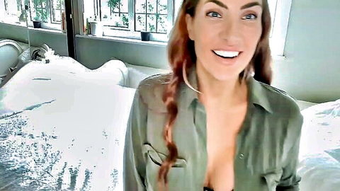 Redhead babe with big tits smiling in unbuttoned green shirt showing deep cleavage