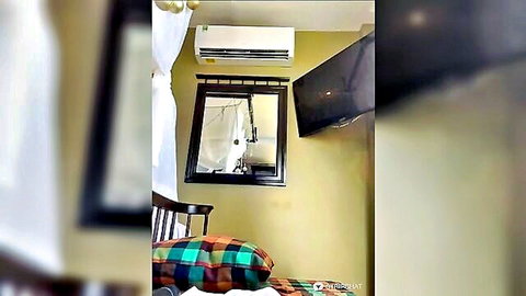 Blurry empty Asian hotel bedroom with AC unit mirror TV and chair
