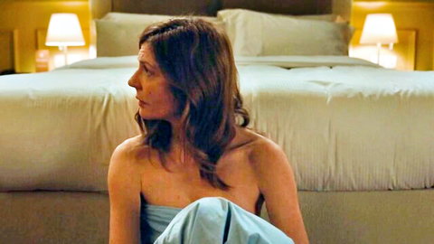Chiara Mastroianni in strapless blue dress, sitting by bed in Chambre 212 (2019)