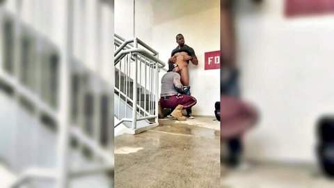 Black men in intense stairwell gay sex, one kneeling behind the other