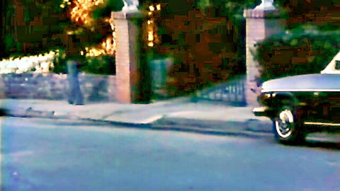 Vintage outdoor driveway gate with brick pillars classic white car parked nearby