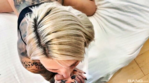 Tattooed blonde Lila Evance giving oral on bed
