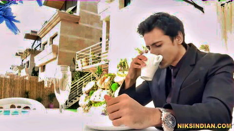 Handsome Indian man in black suit sipping tea at outdoor table, Niks Indian scene