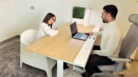 Brunette student in white blouse with glasses at desk with bearded professor