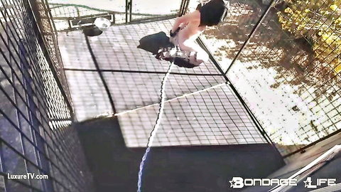 Rachel Greyhound in outdoor hogtie bondage, suspended nude in ropes