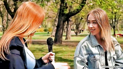 Sexy redhead with big tits interviews cute blonde teen in public park