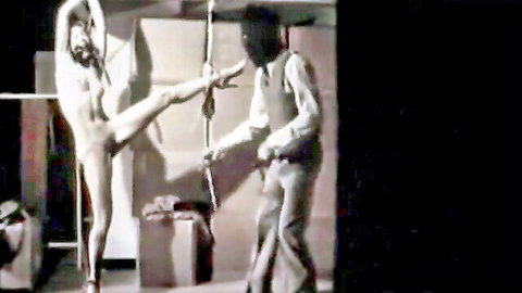 Nude flexible white woman in high leg pose whipped by suited black man BDSM