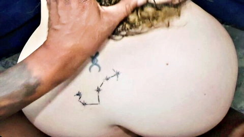 Black man's tattooed hand spreads huge pale white ass cheek with Scorpio tattoo on curvy blonde's big booty