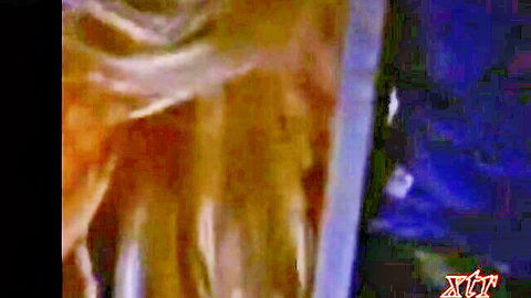 Blurry closeup of orange ropes binding nude slave against blue fabric