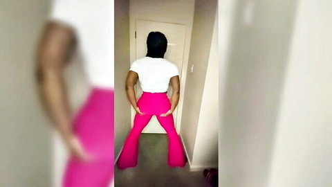 Ebony curvy woman in pink flared pants showing off big round ass