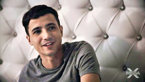Handsome male actor in gray t-shirt on bed in Charlie Forde MissaX teaser, 60 chars